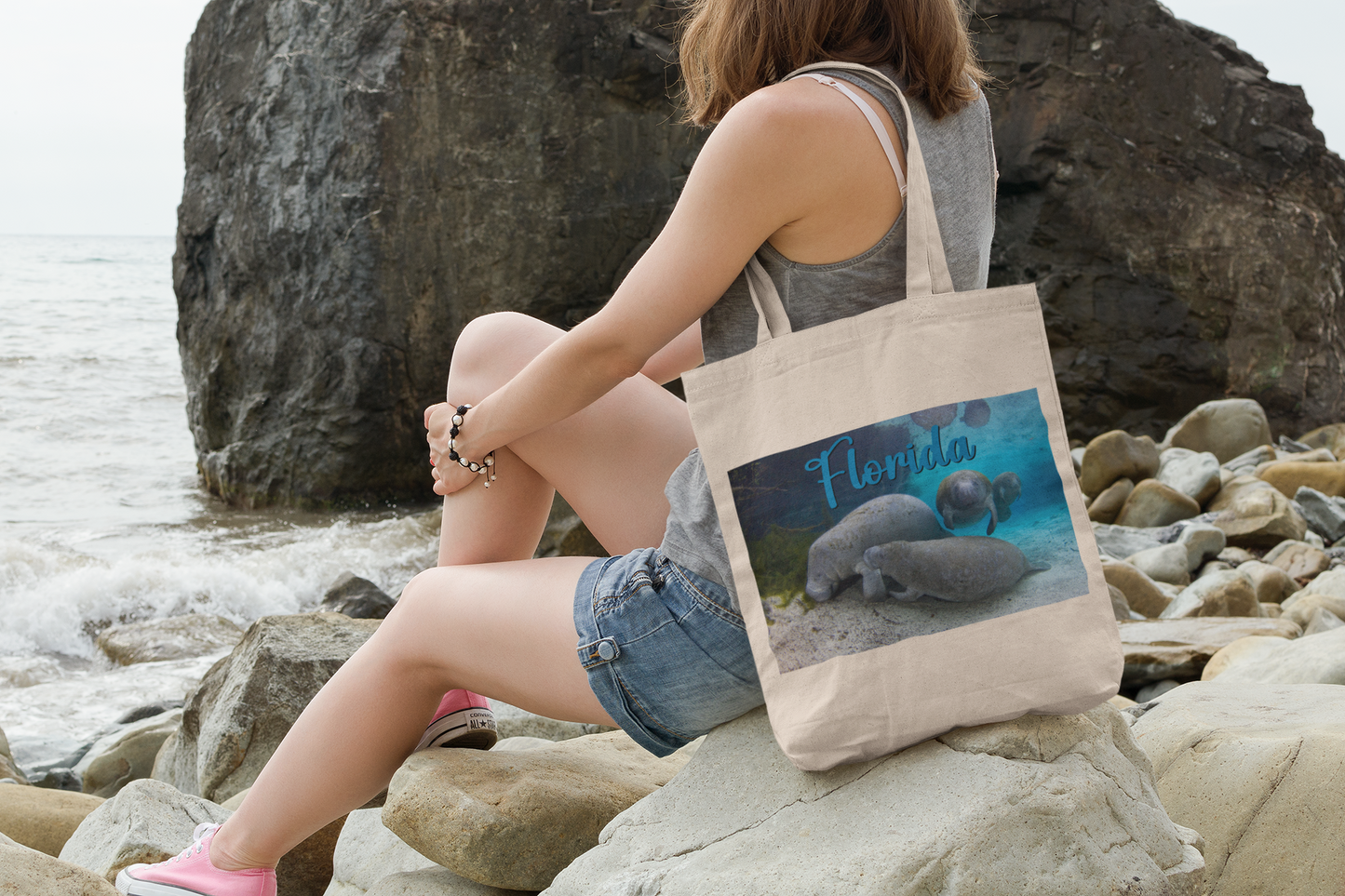 Manatee Feeds Her Calf, model sitting on rocks by ocean