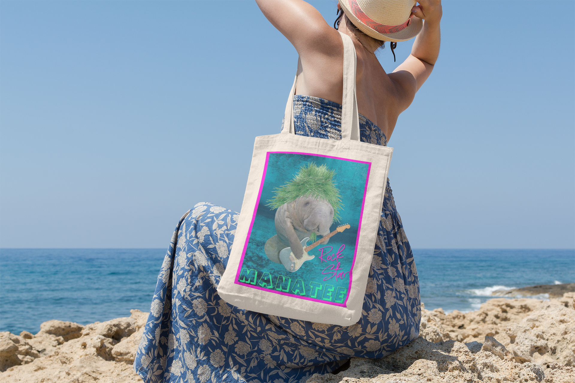 Rock Star Manatee Tote Bag, model sitting on beach overlooking ocean