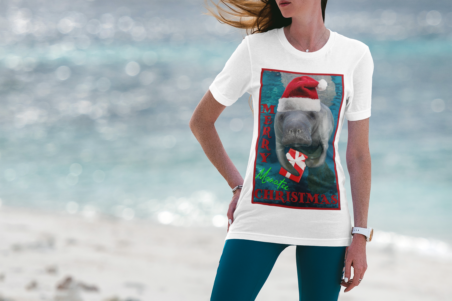 Merry Christmas Manatee Tee, model wearing white t-shirt on beach