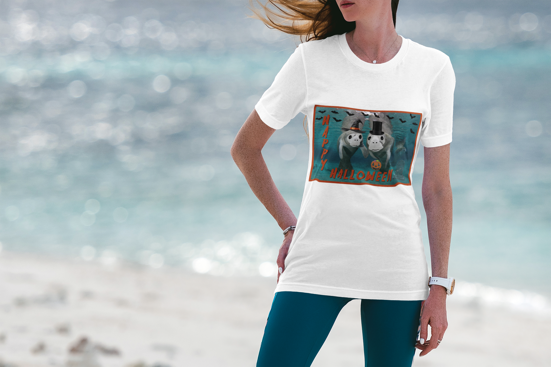 Happy Halloween Manatee Tee, model wearing white t-shirt on beach