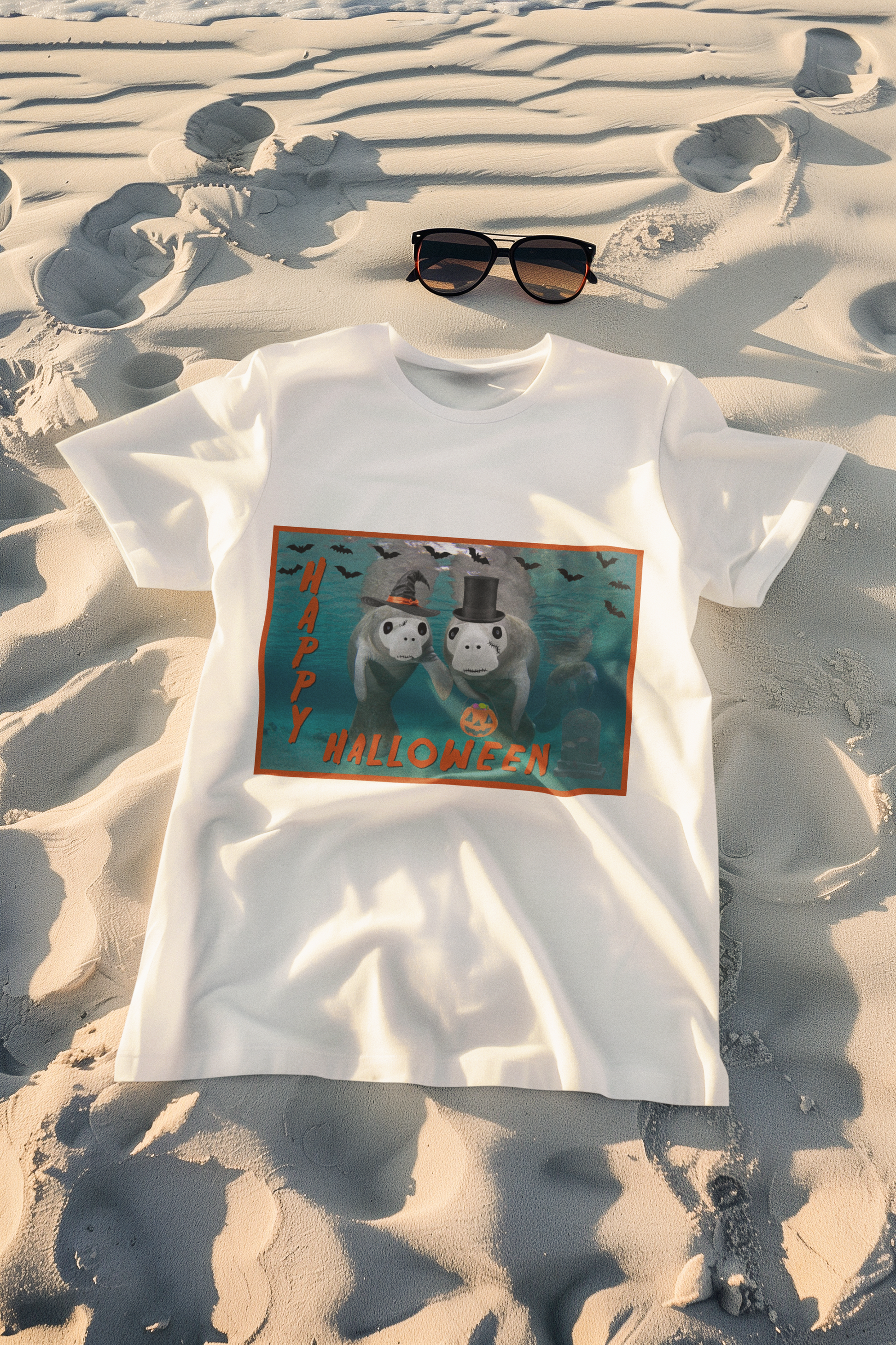 Happy Halloween Manatee Tee, white t-shirt on beach with sunglasses