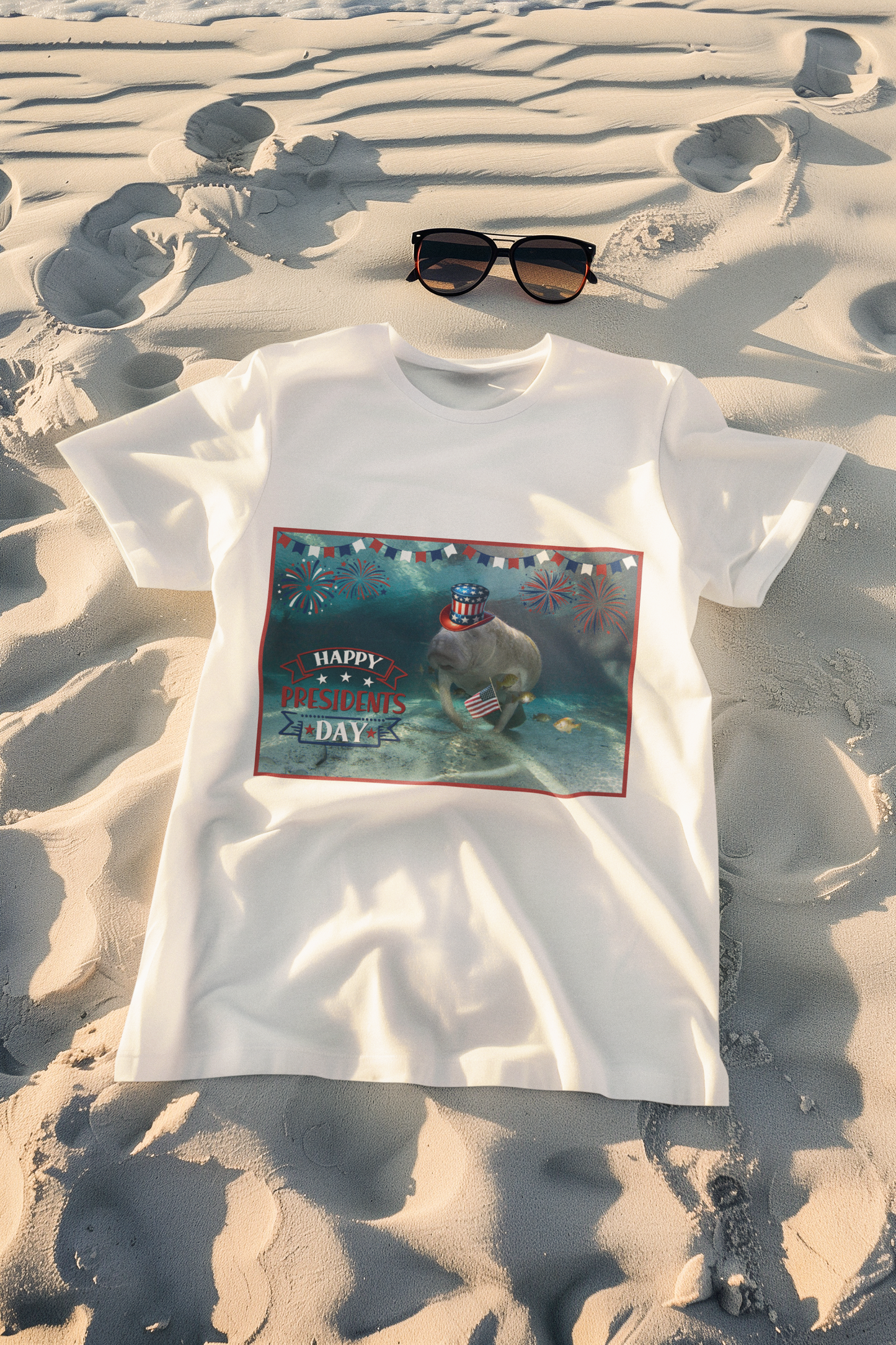 Happy Presidents' Day Manatee Tee, white t-shirt on beach with sunglasses